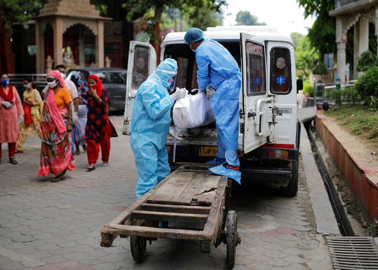 Workers wearing personal protective equipment (PPE) unload a body of a man who died due to the coronavirus disease (COVID-19) before his cremation at a crematorium in New Delhi, India August 22, 2020. REUTERS/Adnan Abidi?